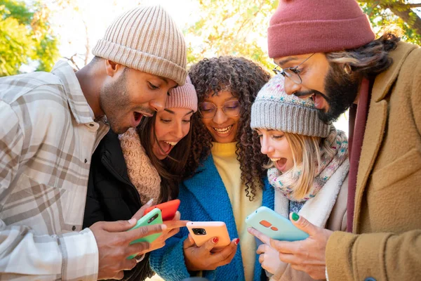 Een Groep Jonge Vrienden Die Mobiele Telefoons Gebruiken Verraste Uitdrukking Rechtenvrije Stockafbeeldingen