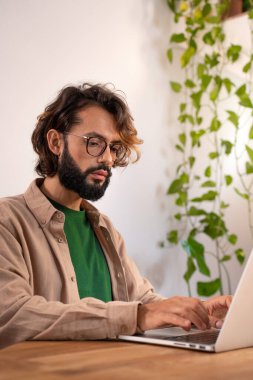 Neşeli erkek yazar evde dizüstü bilgisayarında bir roman üzerinde çalışıyor. Yüksek kalite fotoğraf