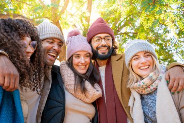 Arkadaşların parkta fotoğraf çektirmek için gülümsüyor ve birlikte eğleniyorlar. Yüksek kalite fotoğraf