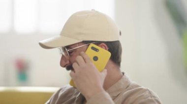 Mutlu, güler yüzlü, tasasız, olumlu konuşan cep telefonlu, dost canlısı, güler yüzlü, neşeli, sıradan bir konuşma. Yüksek kalite 4k görüntü