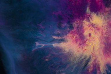 Kozmik bir manzaranın nefes kesici bir tablosu. Mor ve elektrik mavisi kıvrımlı bulutlar, uzaydaki bir galaksiye benziyor.