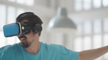Kumandalı sanal gerçeklik gözlüğü kullanan, video oyunları oynayan, evinde eğlence ve eğitim için yeni nesil oyun kulaklığı takan bir adam, gelecekteki teknoloji konsepti. Yüksek kalite 4k