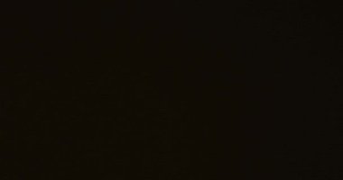 Lens parlıyor, soyut bokeh ışıkları hareket ediyor. Siyah arka planda kristalin yansıması sızıyor. Yüksek kalite 4k görüntü
