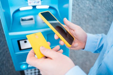 Cep telefonuyla el ele tutuşup benzin istasyonunda ödeme yapacağız. Yüksek kalite fotoğraf