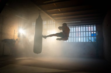 Havadan uçan tekme boksu ya da dövüş sanatları boksörünün spor salonunda kum torbası. Yüksek kalite fotoğraf
