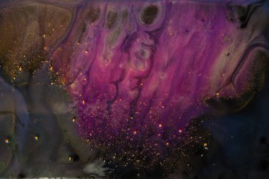 Siyah arkaplana karşı canlı mor ve altın renkli bir tablonun makro fotoğraf çekimi, karmaşık desenler ve detaylarla çarpıcı bir sanat eseri yaratıyor.