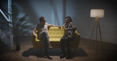 Kanepede röportaj yapan iki adam podcast hakkında konuşuyor. Yüksek kalite 4k görüntü