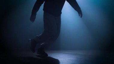 Karanlık bir stüdyo dansçısında dans eden bir adamın silueti. Yüksek kalite 4k görüntü
