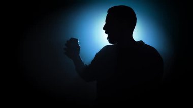 Soda kutusunu yavaş çekimde açıp içen bir adamın silüeti. Yüksek kaliteli FullHD görüntüler