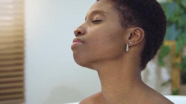 Attractive woman relaxing in foam bath in beautiful bathroom morning routine. Calm, pleasure, happiness and joy concept. 4k shot on RED camera slow motion
