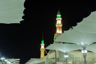 Ön planda şemsiyeli Peygamber Camii minareleri, Medine, Suudi Arabistan