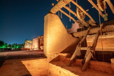Diriyah old town well with highlighted wall in the background at night, Riyadh, Saudi Arabia clipart