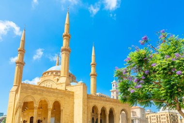 Lübnan, Beyrut 'un merkezinde çiçek açan bir Jakaranda ağacı olan Muhammed El-Amin Camii' nin mavi kubbesi.