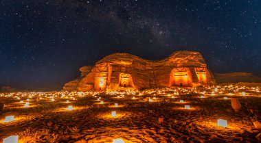 Hegra şehrinin antik Nabataean mezarları üzerinde yıldızlı gökyüzü aydınlandı, gece panoraması, El Ula, Suudi Arabistan