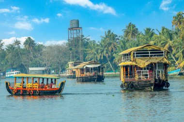 Pamba nehrinde yüzen geleneksel Hint yüzen tekneleri, kıyı şeridinde palmiyeler, Alappuzha, Kerala, Güney Hindistan