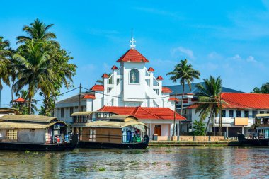 Pamba nehri kıyısındaki eski sömürge Aziz Thomas Katolik Kilisesi, palmiyeler ve demirli yüzen yüzen evler, Alleppey, Kerala, Güney Hindistan