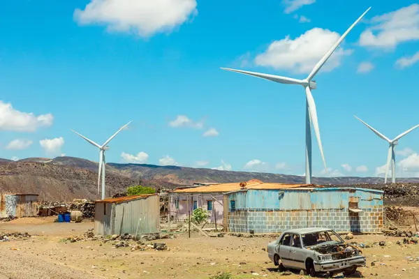 stock image Wind power turbines generators of grid station farms standing behind the ruined village, Ghoubet, Arta Region, Djibouti