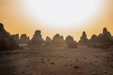 Kireçtaşı bacaların ay manzarası jeolojik kaya oluşumları gün batımı ışınları ile kurumuş tuz gölü Abbe, Dikhil bölgesi, Cibuti