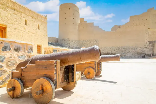 stock image Bahla citadel fortress stone walls and round towers with old cannon the foreground, Bahla, Oman