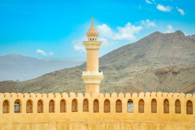 Al Qala 'a Camii, kubbe ve minareyle süslenmiş. Önünde Nizwa kalesi duvarları, Nizwa, Umman sultanı.