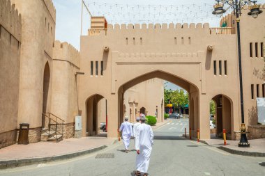 Geleneksel olarak beyaz Thombe 'lar giyip Arap kalesi Nizwa' nın kapısından içeri giriyorlar. Sultan Umman.