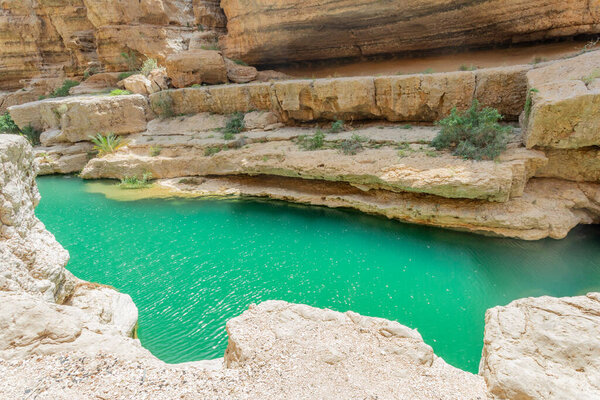 Green lake waters in the middle of Wadi Shab canyon, Tiwi, sultanate Oman