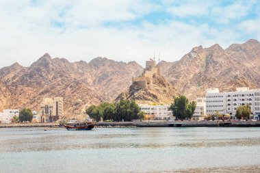 Tepede Mutrah kalesi ve körfezde demirli geleneksel dhow teknesi, Muscat, Sultan Umman ile gezinti güvertesi.
