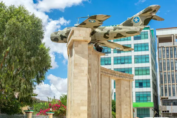 stock image Old war memorial with soviet jet fighter and modern buildings in the  downtown streets of Hargeisa, Somaliland, Somalia