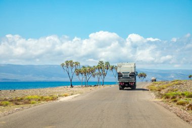 Road with trucks along Tadjourah gulf with mountains in the background, Tajourah, Djibouti clipart