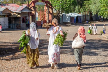 Etiyopyalı kadınlar geleneksel kıyafetler giyip Etiyopya 'nın Lalibela, Amhara Bölgesi sokaklarında yürüyorlar..