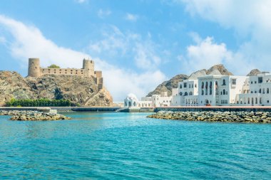 Kayaların üzerinde duran Arap Al Jalali şatosuna ve beyaz saray binalarına bakın, Muscat, Umman