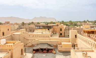 Arka planda eski harabe şehir Nizwa, Sultan Umman, Arap kalesi merdiven, kule ve duvarlı iç bahçe manzaralı.