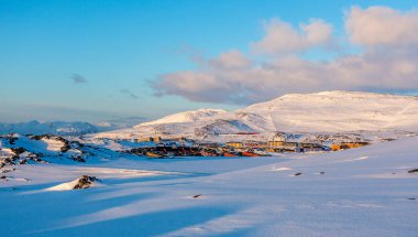 Nuuk şehrindeki tepelere dağılmış bir sürü Eskimo evi karla kaplı arka planda dağlar, Grönland