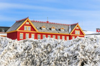 Önünde kar yığınları olan eski kırmızı Danimarka kolonisi Nuuk, Grönland 'ın tarihi merkezi.
