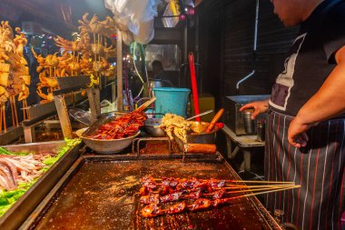 Şehir merkezindeki markette, Xian, Shaanxi, Çin 'de, deniz mahsulleri yemek sokağında yağda kızartılmış karides ve kalamar.