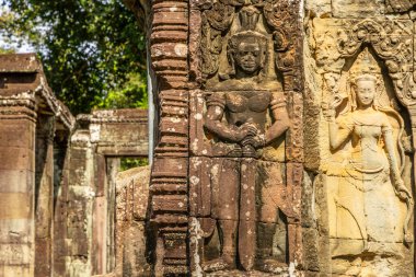 Antik Hindu Banteay Kdei Khmer savaşçı dvarapala ve kadın apsara figürü, Angkor Arkeoloji Parkı, Siem Reap, Kamboçya ile süslenmiş tapınak sütunlarını harap etti