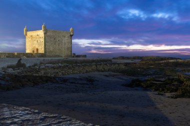 Bir liman ve Essaouira Sqala Limanı 'nda mavi balıkçı tekneleri, güneş batarken Portekiz kalesi, Essaouira, Fas