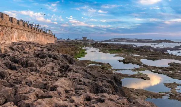 Akşamları Portekiz Mogador Kalesi, Essaouira Fas Kalesi, Skala de la Villa kalesinin duvarlarında gelgit gölleri olan Fas kasabası.