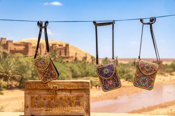 Fas 'ın Ouarzazate bölgesindeki antik Ait Benhaddou Ksar köyünün pazar caddelerinde satılan renkli geleneksel hatıra çantaları.
