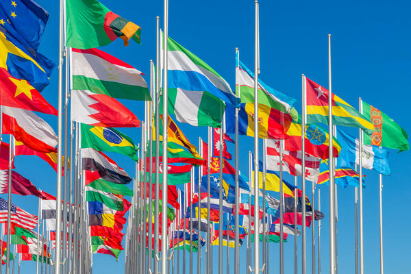 Многие страны мира национальные флаги размахивают на ветру, с таджикскими, бахрейнскими, нигерийскими молдавскими баннерами на переднем плане, Доха, Катар