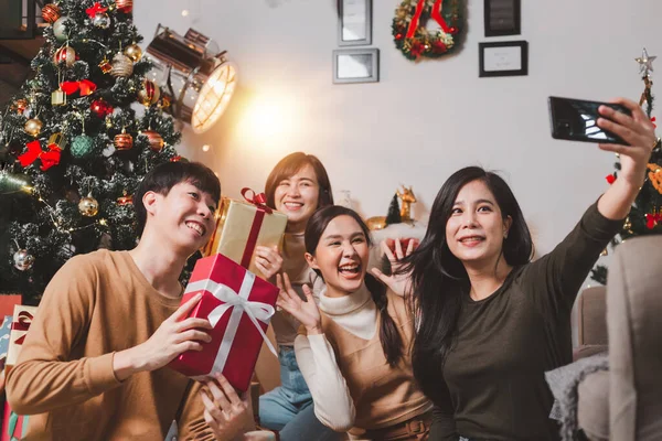 기사보기 크리스마스와 새해를 기념하는 아시아 젊은이들 크리스마스 스마트폰에 셀카를 상자를 — 스톡 사진