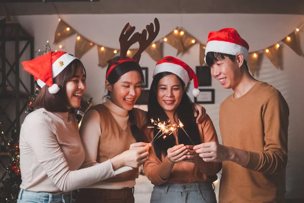 No Dia De Natal, Um Grupo De Amigos Olhando Para A Árvore De Natal Decorada  No Quarto, Sorrindo E Rindo. Foto Royalty Free, Gravuras, Imagens e Banco  de fotografias. Image 65786586