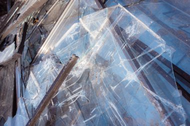 Lots of broken glass. Broken windows of a high-rise building collected on a trash can. Consequences of a massive rocket attack. Consequences of military actions. clipart