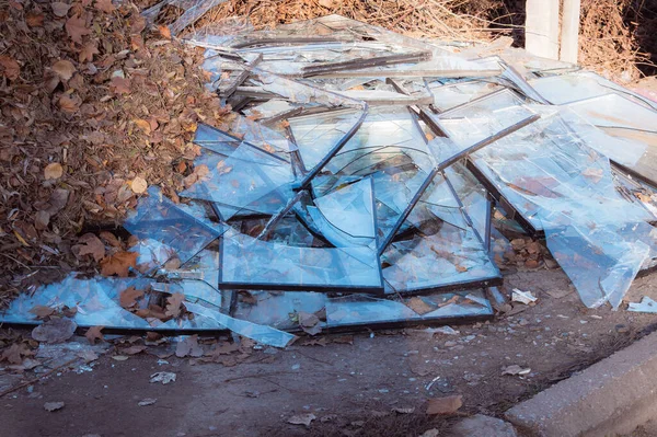 Bir sürü kırık cam var. Bir çöp kutusunda toplanan yüksek katlı bir binanın kırık camları. Büyük bir roket saldırısının sonuçları. Askeri eylemlerin sonuçları.