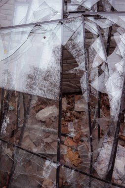 Bir sürü kırık cam var. Bir çöp kutusunda toplanan yüksek katlı bir binanın kırık camları. Büyük bir roket saldırısının sonuçları. Askeri eylemlerin sonuçları.