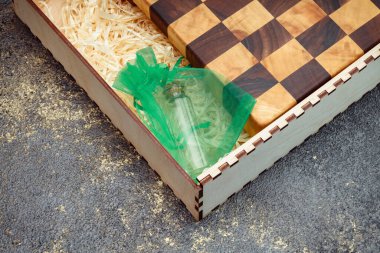 End cutting board on a dark textured background. Kitchen utensils made of natural wood. Expensive vintage items. Luxurious quality woodworking. Chess pattern on a wooden board