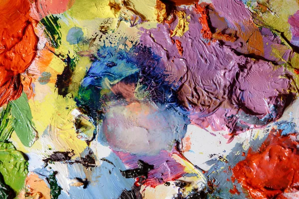 Colorful abstract texture. Smears of oil paint on an art palette. The concept of the modern school of art. Fragment of creative work. Colors of the year 2023