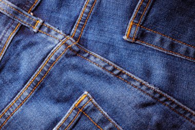 Kot pantolon giyiyordu. Makine dikişi yakın. Mavili Denim dokusu. Eski giysileri tamir etme kavramı. Dikiş fabrikası. Modaya uygun yaşlanma kıyafetleri..