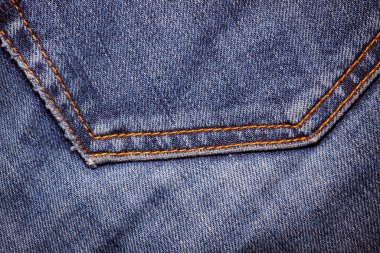 Kot pantolon giyiyordu. Makine dikişi yakın. Mavili Denim dokusu. Eski giysileri tamir etme kavramı. Dikiş fabrikası. Modaya uygun yaşlanma kıyafetleri..