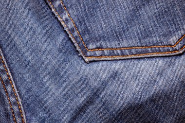 Kot pantolon giyiyordu. Makine dikişi yakın. Mavili Denim dokusu. Eski giysileri tamir etme kavramı. Dikiş fabrikası. Modaya uygun yaşlanma kıyafetleri..